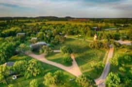 Large panoramic overhead view of vineyards and houses in rolling green hills.