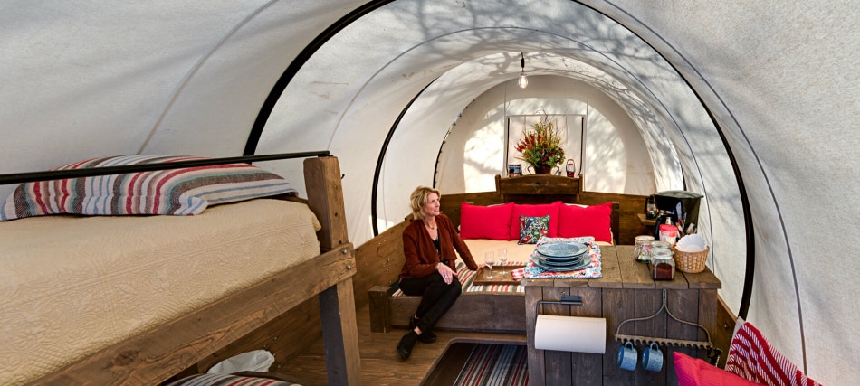 A glamping tent with a bunk bed, sofa, coffee table, and rug