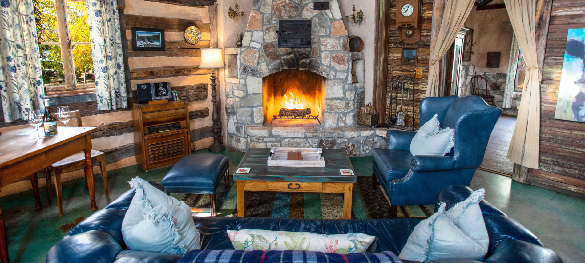 A cozy lobby with a stone fireplace, leather furniture, and wooden decor.